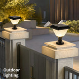 Solar Pillar Light Outdoor Post Cap Lantern. Two outdoor solar post caps mounted on stone gate pillars, casting warm light in a modern patio and garden setting. 