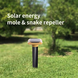 Solar energy mole & snake repellent on grass with trees in the background